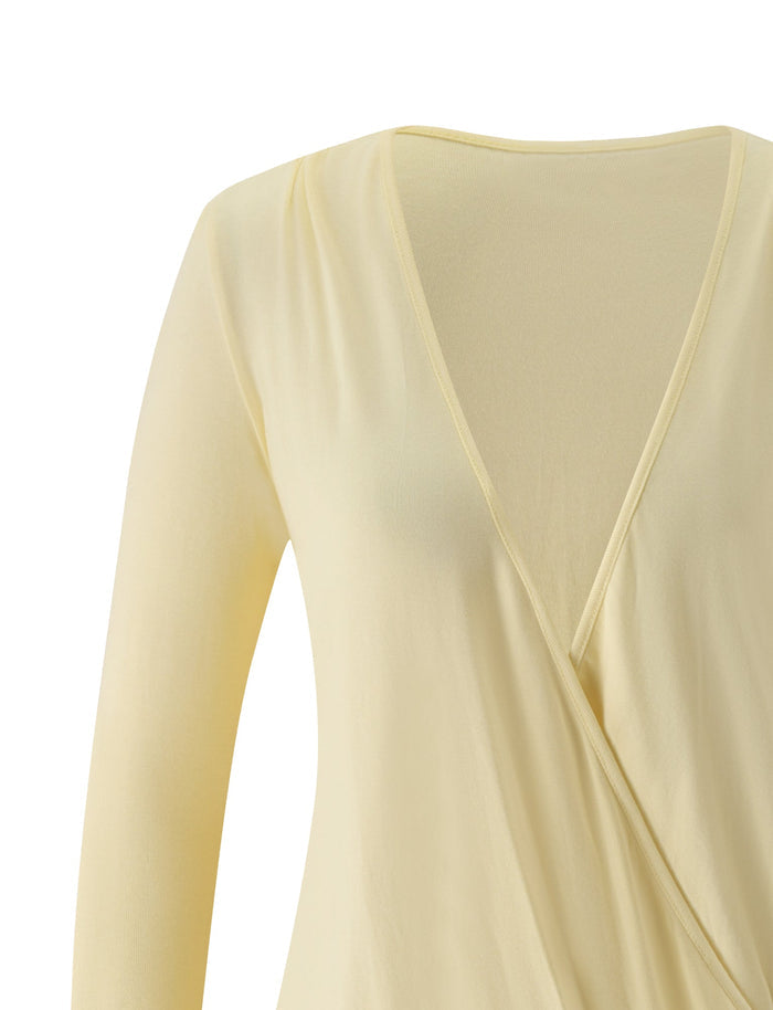 A close-up of the TIGERMIST FOXLEY MINI DRESS in butter cream—a pale yellow long-sleeve mini dress featuring a deep V-neck and wrap-style front—perfect for your next beach club outfit, shown against a plain white background.