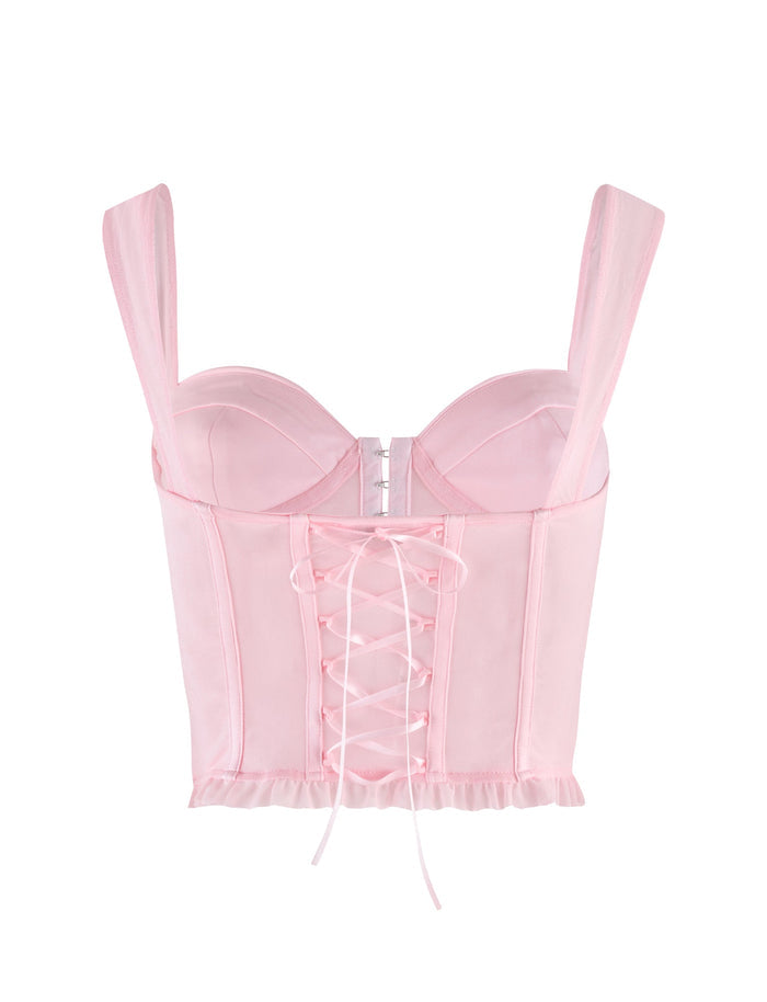 The TIGERMIST GINNY TOP in baby pink is a satin corset with a sweetheart neckline, wide straps, underwire cups, front hooks, center lace-up detail, and a ruffled hem.