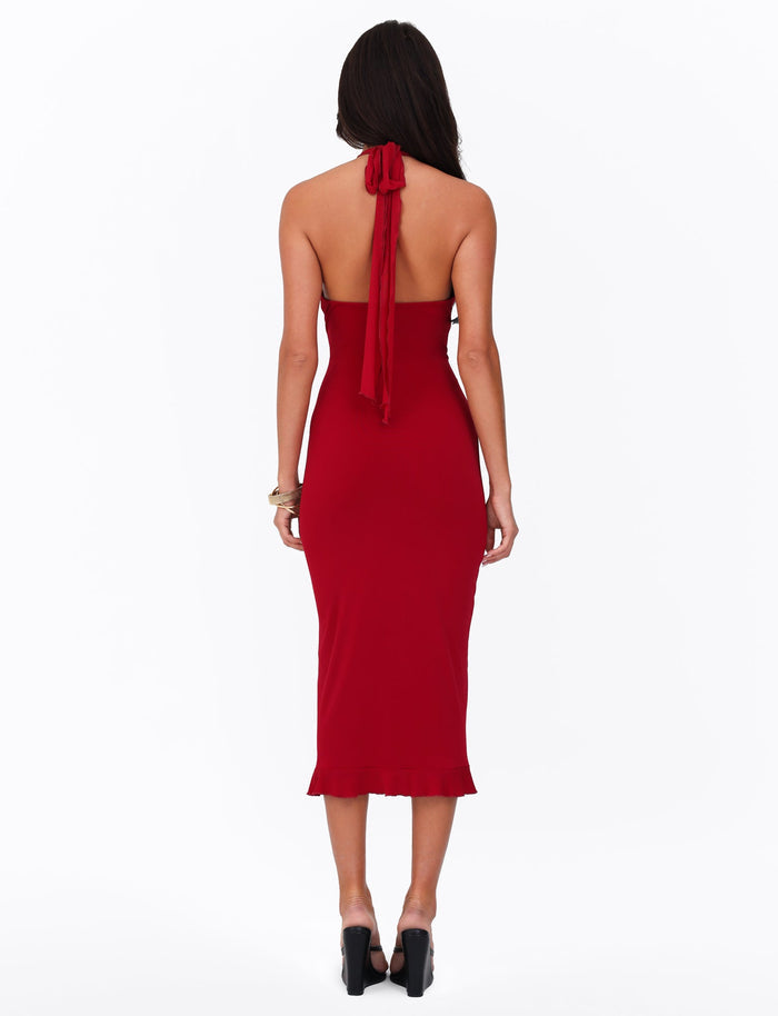 A rear view features a woman in the TIGERMIST GRANGER MIDI DRESS - RED in cherry red, showcasing a sleeveless halter-neckline design. Her long dark hair cascades down her back as she stands poised in high-heeled black shoes against a plain white background.
