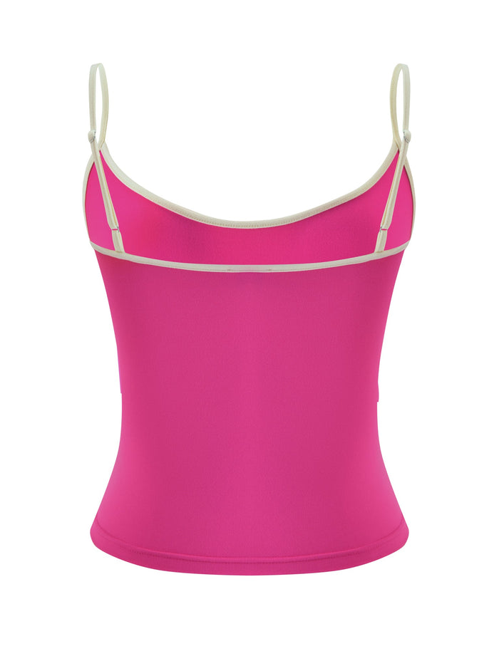 The GREER TOP - HOT PINK by TIGERMIST is a vibrant hot pink singlet tank top made from buttery jersey fabric, detailed with thin white trim and adjustable spaghetti straps, shown from the back against a white background.