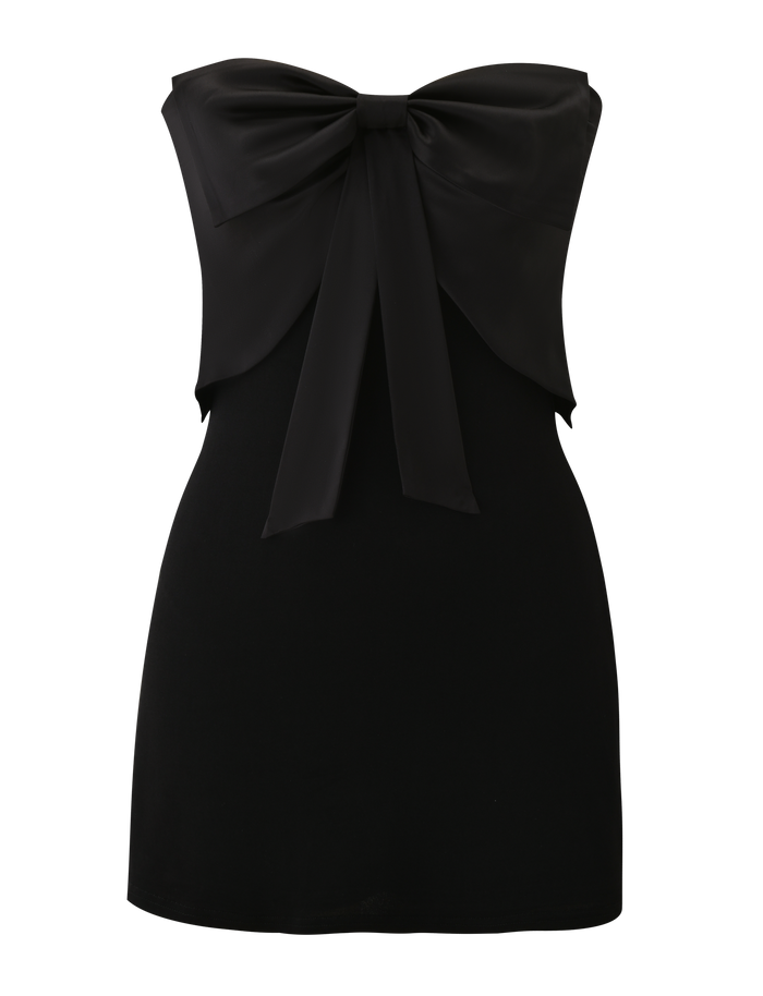 The GROVE MINI DRESS - BLACK by TIGERMIST is a strapless, fitted mini dress made from shiny fabric, featuring a bold satin bow across the chest and a plain silhouette, shown against a white background.