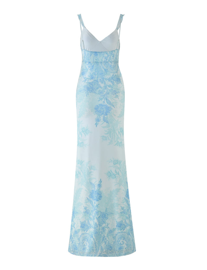 The TIGERMIST GUILIANNA FRILL MAXI DRESS offers a sophisticated and timeless style with its sleeveless, floor-length design. It showcases a fitted silhouette adorned with an asymmetric frill and features a light blue floral tapestry pattern on a white backdrop.