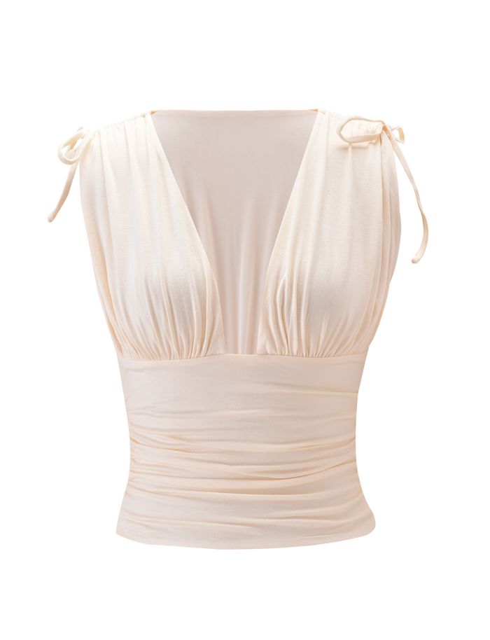 The HALONA TOP - CREAM by TIGERMIST is a sleeveless top with a plunging ruched bodice, deep V-neckline, adjustable shoulder ties, and a fitted gathered waist in soft, slightly shiny fabric. Shown on a plain white background.