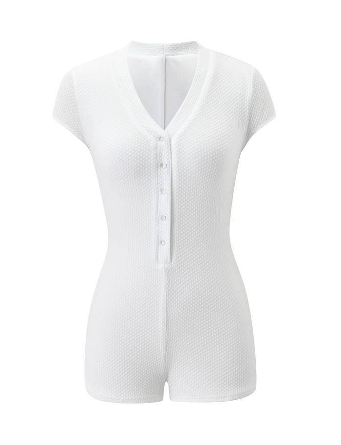 The HILSIE PLAYSUIT by TIGERMIST is a white, short-sleeve waffle knit romper featuring a V-neckline and button-down front, shown on a plain white background.