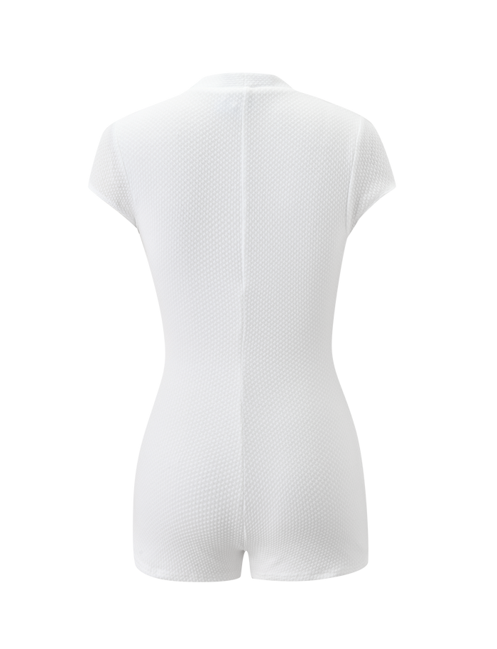 A back view of the HILSIE PLAYSUIT by TIGERMIST, a fitted white waffle knit romper with short sleeves and legs, shown on a plain white background.