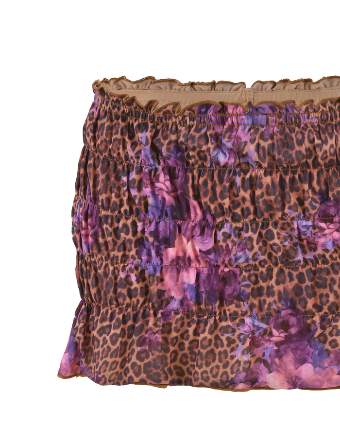 A close-up of the TIGERMIST HOLLIS SKORT in FLORAL LEOPARD, showcasing a bold brown, black, purple, and pink floral leopard print with horizontal elasticated shirring for texture.