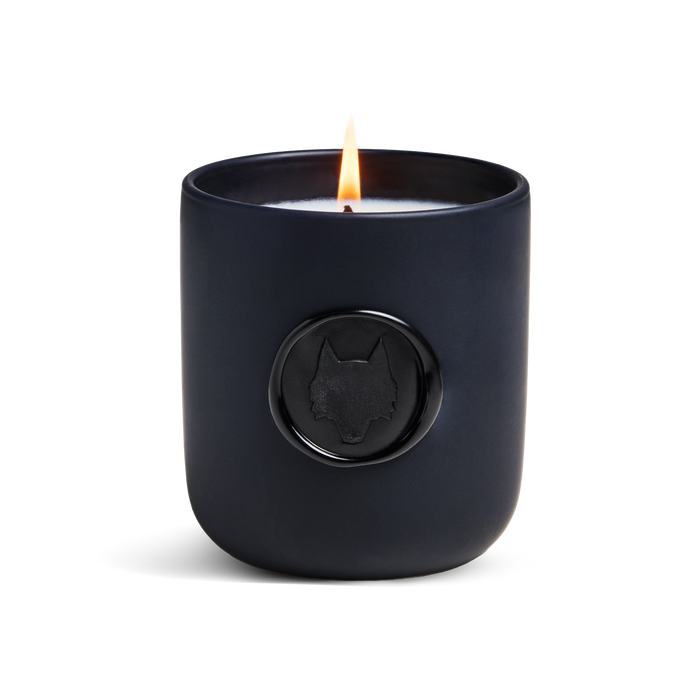 Icon Wolf Wax Seal Fig Scented Candle lit, matte navy vessel with wolf emblem wax seal - Front View | Greyson Clothiers