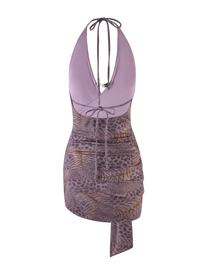 The INDIGO MINI DRESS - PURPLE TIGER by TIGERMIST is a sleeveless lilac halter mini dress with a plunging neckline, tie-up back, and a ruched asymmetrical skirt in high-stretch purple tiger print fabric.