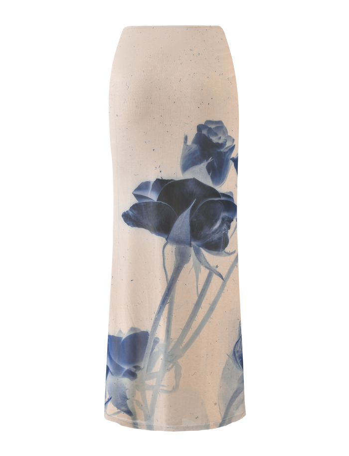 The TIGERMIST JANIS MAXI SKIRT - INDIGO FLORAL is a cream maxi skirt with a bold indigo rose print on the front, featuring an upward floral design from the hem.