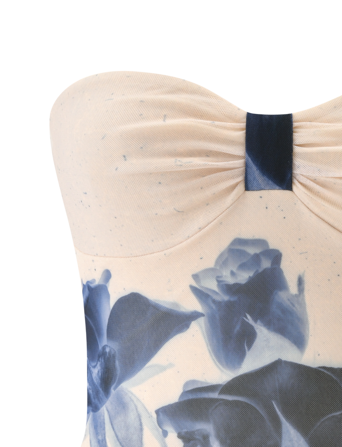 Close-up of the JANIS TOP - INDIGO FLORAL by TIGERMIST, a strapless sweetheart tube top with a gathered, ruched bodice in light beige featuring a bold blue floral print.