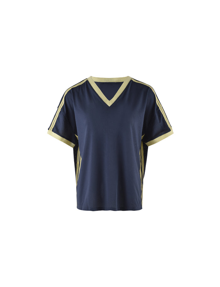 The JAYNA TEE - BLUE in Dusty Blue by TIGERMIST is a blue short-sleeve sports jersey featuring a V-neck collar and light yellow accents along the collar, sleeve edges, and side strips. The jersey is displayed on a plain white background.