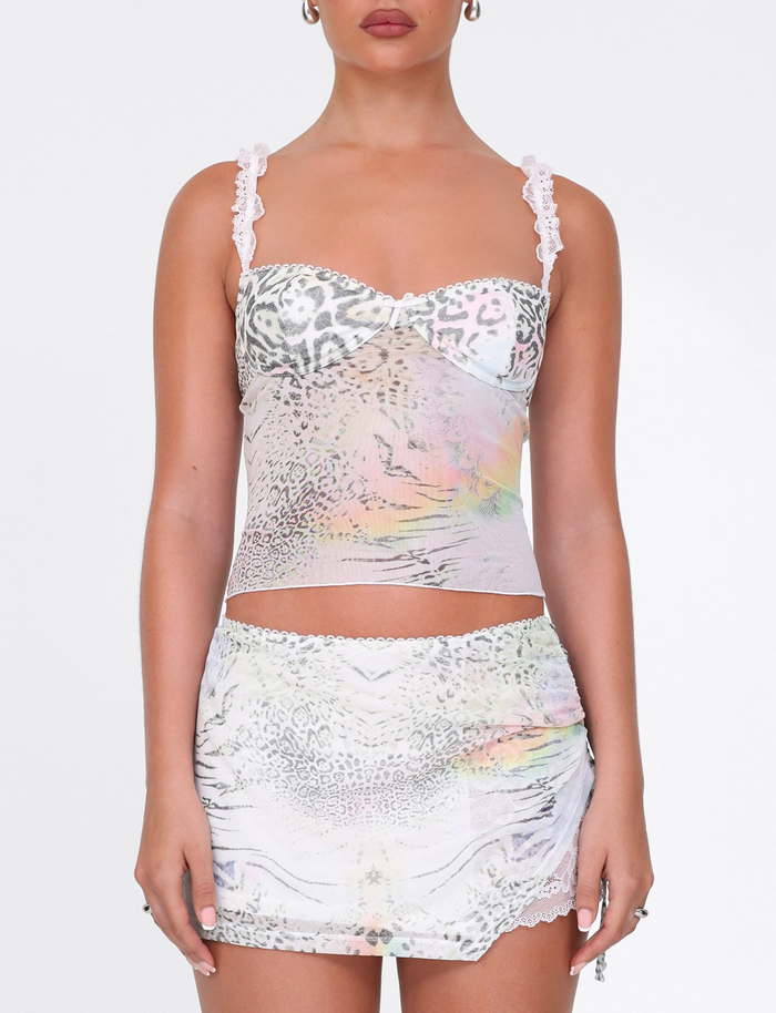 A woman wears the TIGERMIST JOSEPHINE TOP in white animal print with lace straps and a matching mini skirt, standing against a plain white background.
