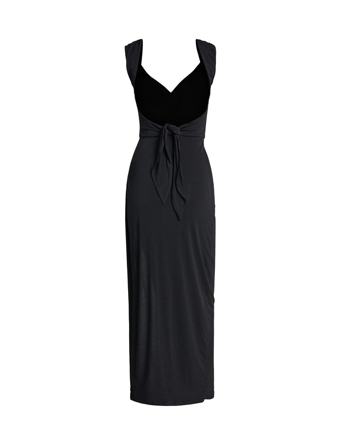 The JOSLIN MAXI DRESS - BLACK by TIGERMIST is a sleeveless, long black dress that features a fitted bodice, V-neck, and wide shoulder straps. It boasts a knotted tie detail at the waist and falls to mid-calf length with a straight, flowing skirt.