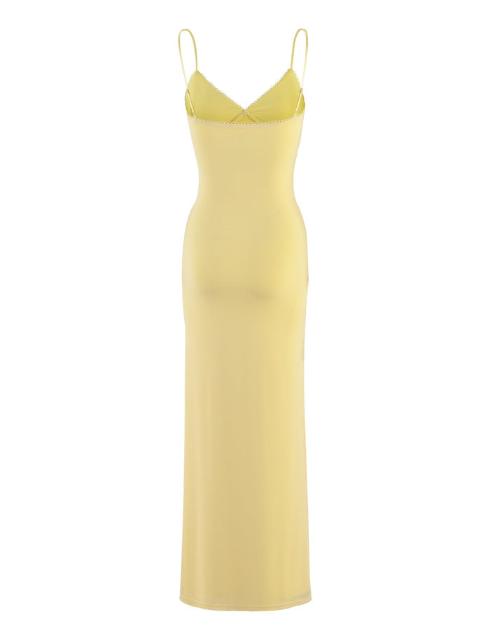 The JULIANNA DRESS - YELLOW : LEMON by TIGERMIST is a long, form-fitting dress featuring spaghetti straps and a slightly flared hem. This elegant piece boasts a smooth texture and simple design, making it ideal for both casual and semi-formal occasions.