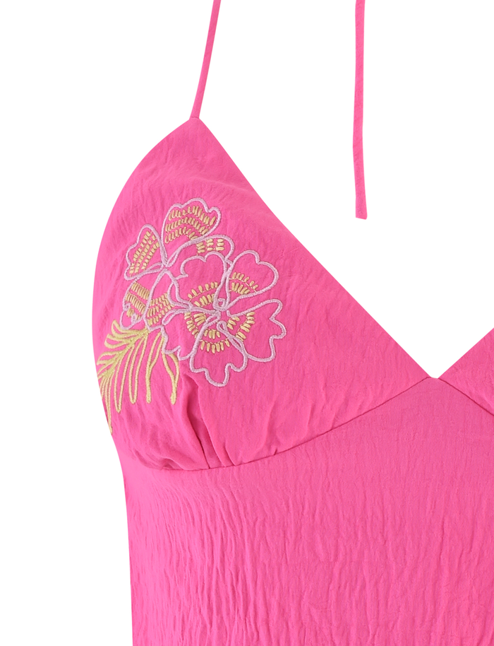 Close-up of the TIGERMIST KAELAH TOP in hot pink featuring spaghetti straps, yellow and white floral embroidery on the chest, a slightly crinkled fabric texture, and an open back for a delicate, modern style.