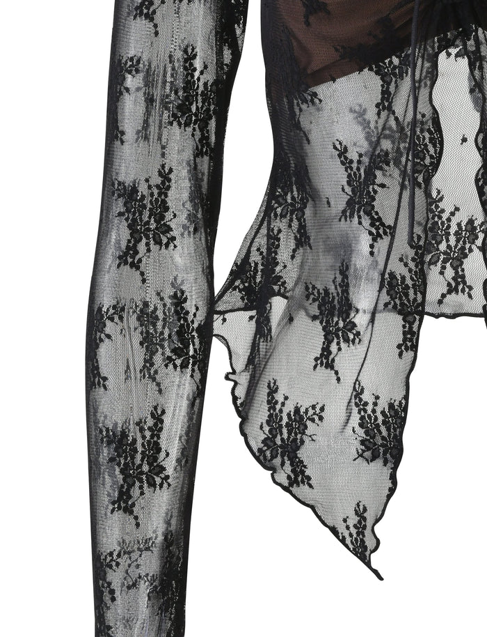 Close-up of a lace sleeve in the Karolina Long Sleeve Top - Black by Tigermist, showcasing intricate floral patterns. The sheer fabric of this design reveals delicate details and a scalloped edge, hinting at an elegant and sophisticated garment.