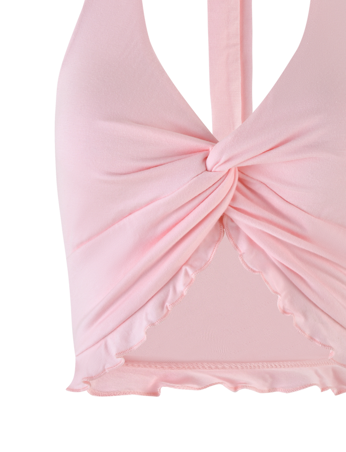 Close-up of the KATYA HALTER TOP by TIGERMIST in pale pink, featuring a halter neckline, twist front detail, and ruffled hem.