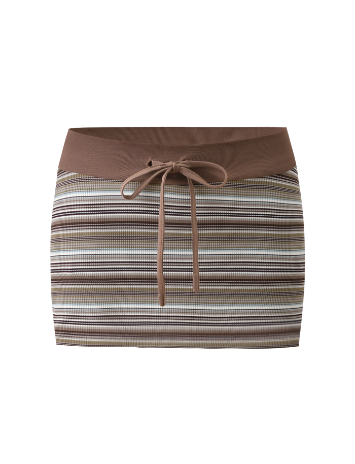 The KAYDIN SKORT - MULTISTRIPE by TIGERMIST is a rib knit bodycon micro mini skort with horizontal brown, beige, and white stripes, a solid brown waistband, hidden shorts, and front tie detail. Shown on a plain white background.