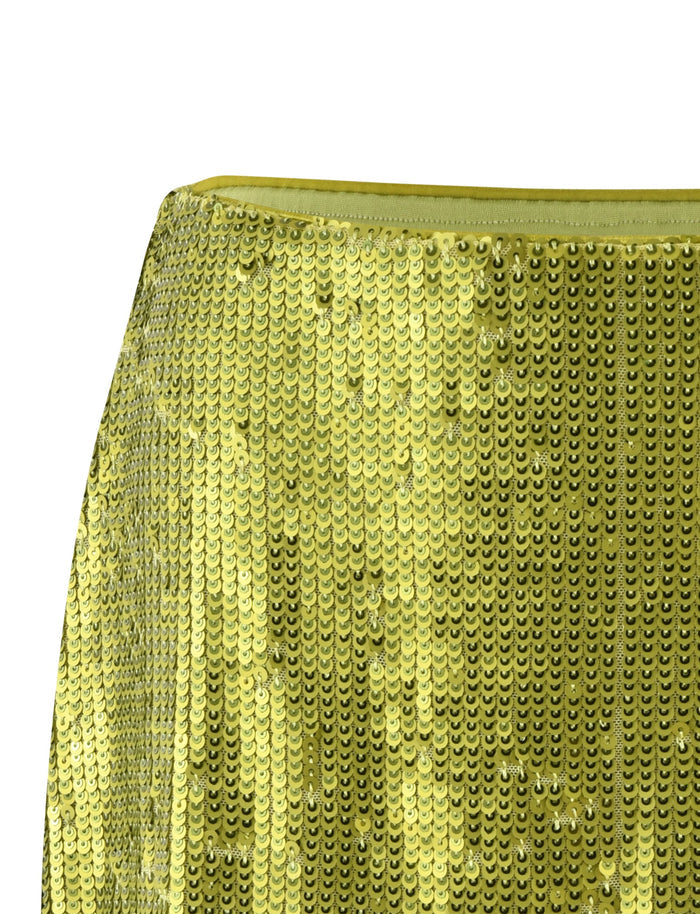 Close-up image of a shiny fabric covered in metallic green sequins, creating a shimmering effect. The sequins are circular and densely packed, reflecting light and giving the fabric a sparkly appearance. This dazzling material looks like it could be part of the TigerMist Kaye Skirt in green.