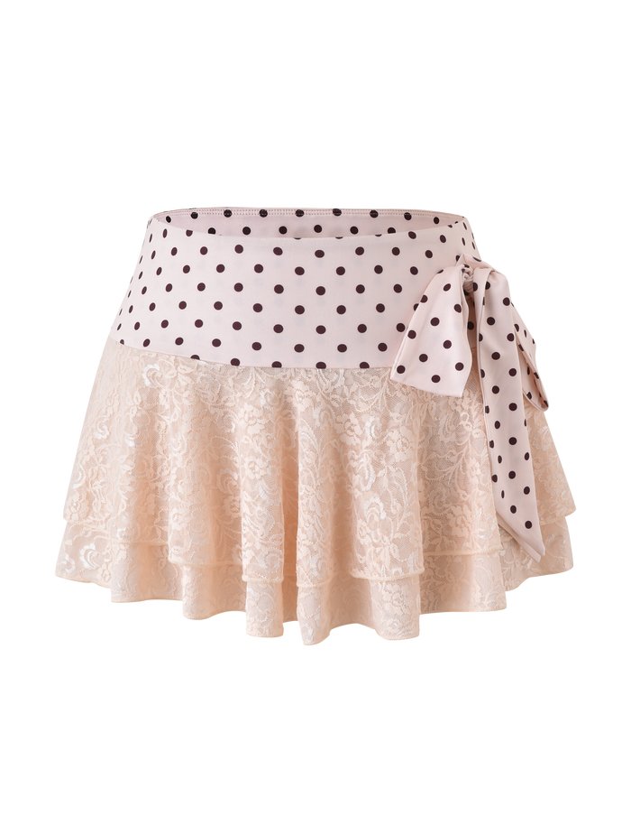 The TIGERMIST KAYLI MINI SKIRT in cream features a chic tiered lace floral pattern, a wide black polka dot waistband, and a statement side bow.