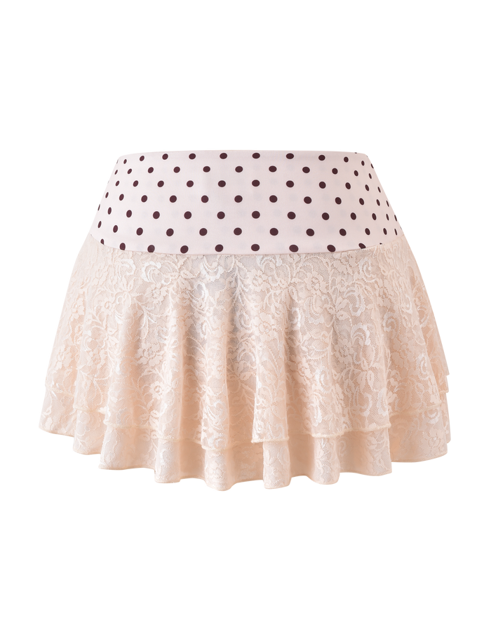 The KAYLI MINI SKIRT by TIGERMIST is a cream-colored, tiered lace skirt with a flared ruffled hem, wide waistband, and features brown polka dots on a white background.