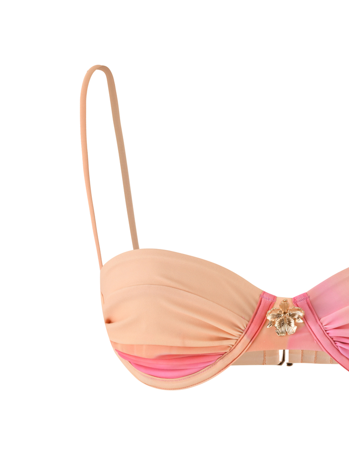 The KHESSA BIKINI TOP - PINK HIBISCUS by TIGERMIST features a peach and pink balconette style with a sweetheart neckline, thin adjustable straps, and gold metal flower detail at the center.