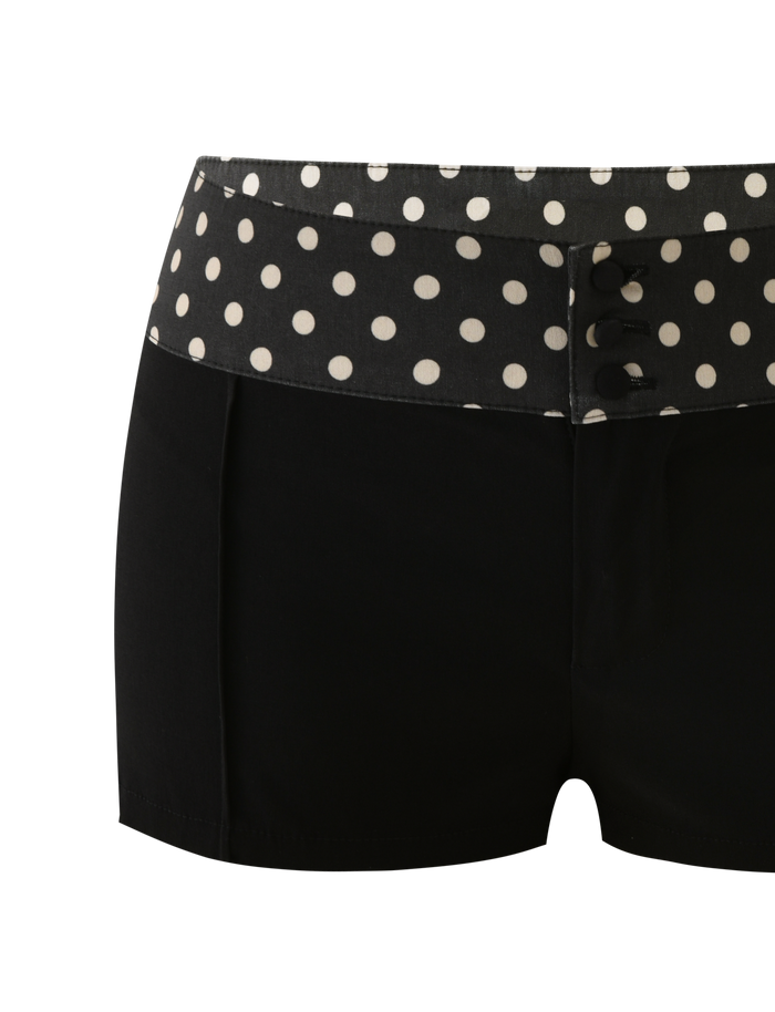 The TIGERMIST KITTIE 2.0 SHORT - BLACK features a polka dot waistband, three black front buttons, and smooth Kittie fabric for a chic, fitted look with playful details.