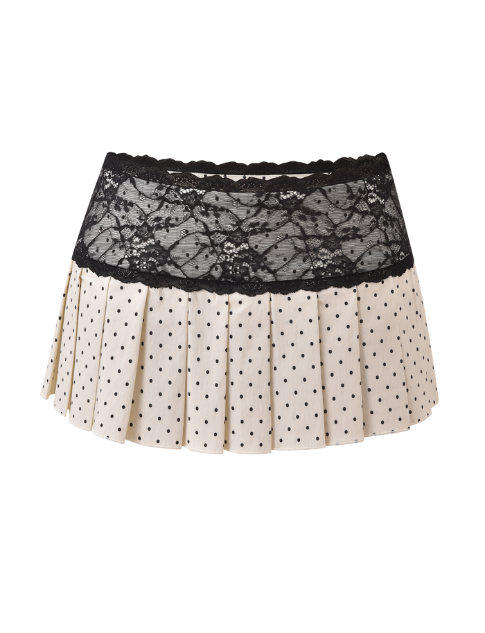 The TIGERMIST KITTIE LACE SKORT - CREAM DOT features a cream pleated mini design with playful polka dots, a wide black lace waistband, and stretch suiting fabric, shown on a plain white background.