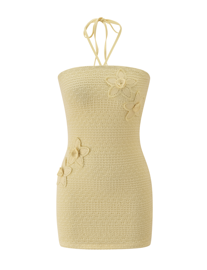 The KORRI DRESS - BUTTER by TIGERMIST is a sleeveless light yellow knit mini with a halter neck tie and three front crochet floral appliques.