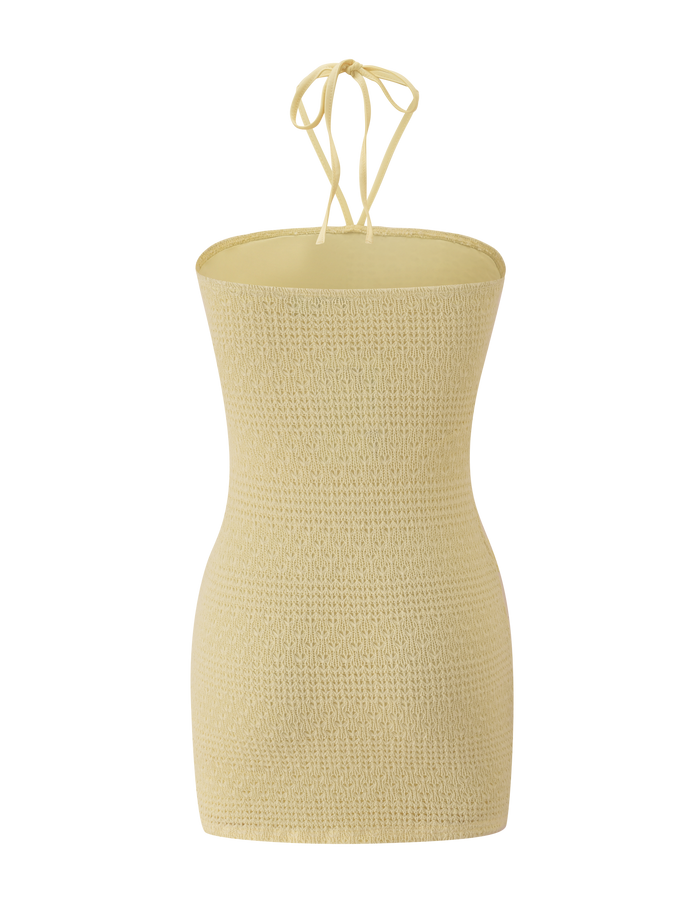 The KORRI DRESS - BUTTER by TIGERMIST is a light yellow, textured dress with a strapless neckline and halter tie, shown on a plain white background.