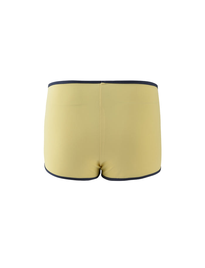 A pair of pale yellow women's bikini bottoms, seen from the back, exude the stylish elegance synonymous with TIGERMIST. The bikini bottoms showcase a smooth texture and are accented with subtle detailing around the waist and leg openings.