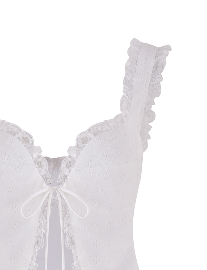 The KYANA TOP - WHITE by TIGERMIST features floral embroidery, ruffled straps, a front bow tie, sweetheart bust, lace trim, scalloped edges, and a keyhole below the bow for a feminine touch.