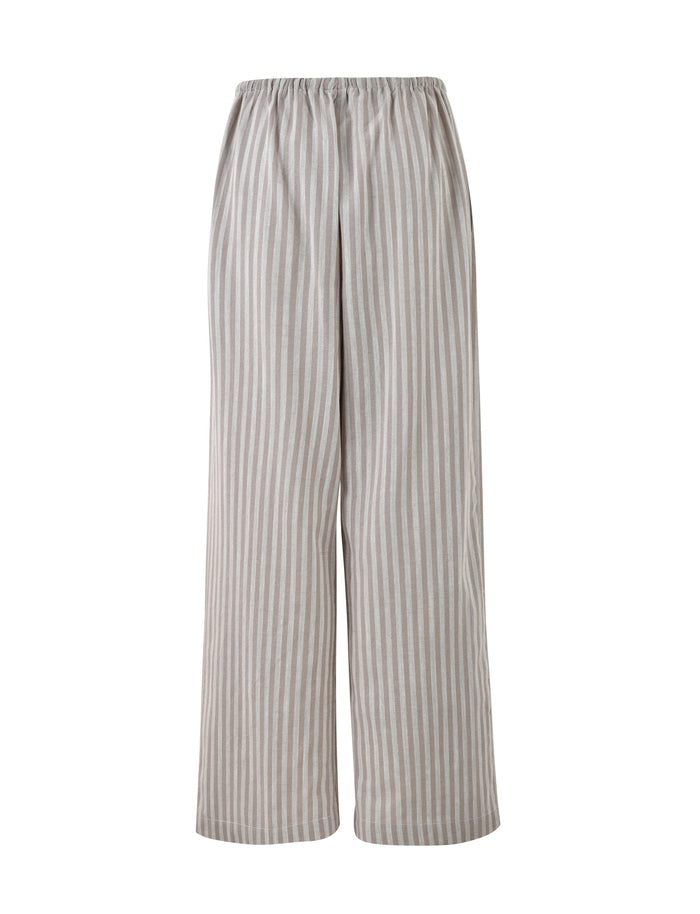 A pair of LAINEY PANT - GREY : STRIPE by TIGERMIST, featuring a loose fit with high-waisted, wide-leg design and an elastic waistband. The lightweight, breathable fabric is adorned with vertical white and light brown stripes.