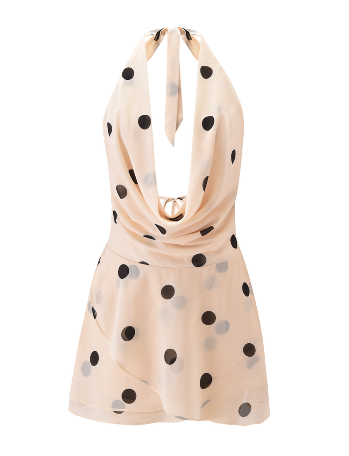 The LATHAN MINI DRESS by TIGERMIST features a sleeveless cream chiffon design with black polka dots, a cowl neckline, tiered flounce skirt, and halter tie for a chic, playful look.
