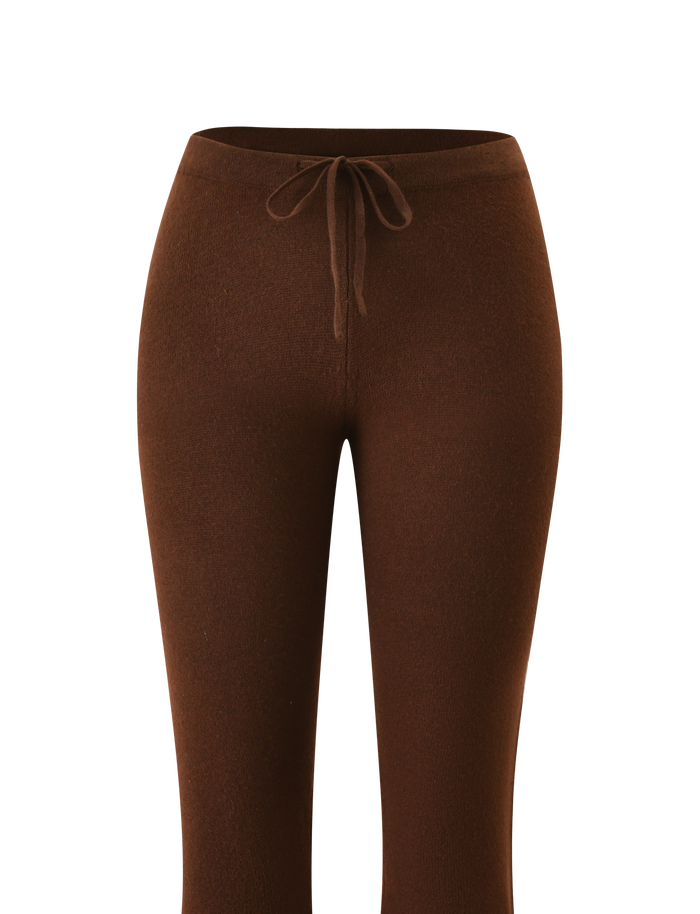 The TIGERMIST LEORA PANT - CHOCOLATE features a fitted silhouette, drawstring waist, and soft stretchy fabric for comfort. Flared legs add a modern touch. Shown against a white background.