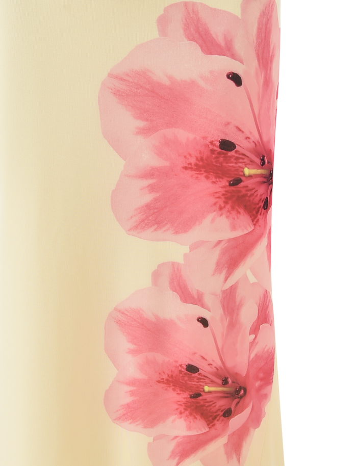 Close-up of the LILLIAN SKIRT - YELLOW by TIGERMIST, featuring two large pink flowers with black and yellow stamens on a pale yellow background, evoking a floral print design.