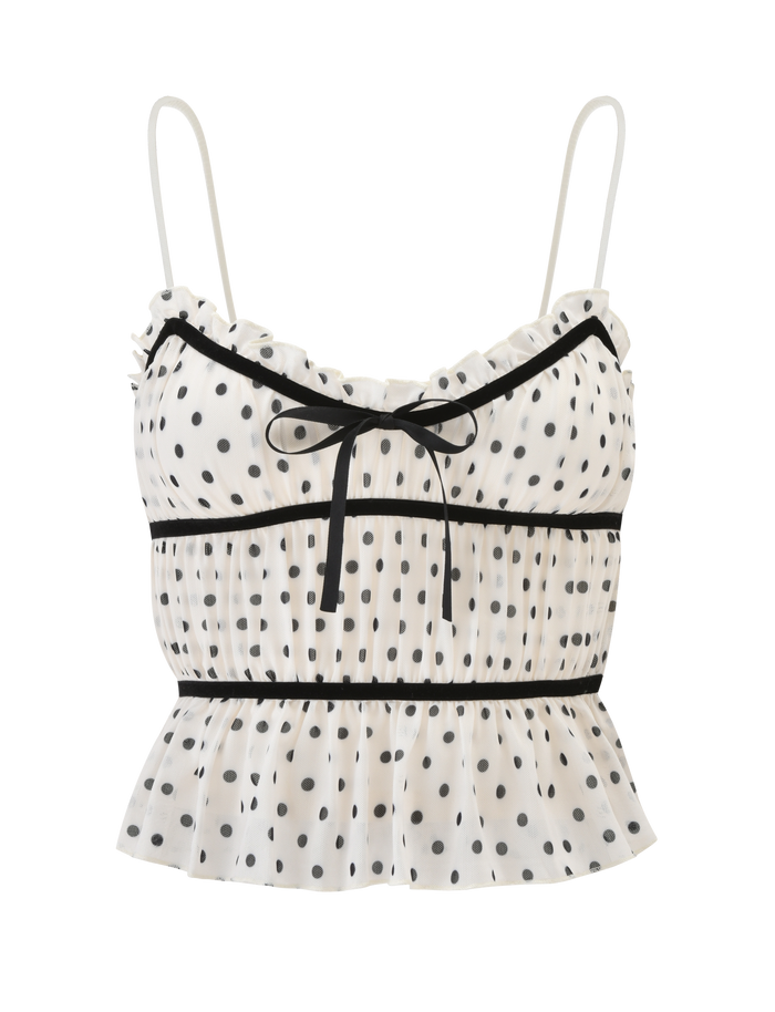 The LIORA TOP - POLKA DOT by TIGERMIST is a white, sleeveless cami featuring adjustable straps, black ribbon detailing with a center bow, playful polka dots, and a ruffled hem.