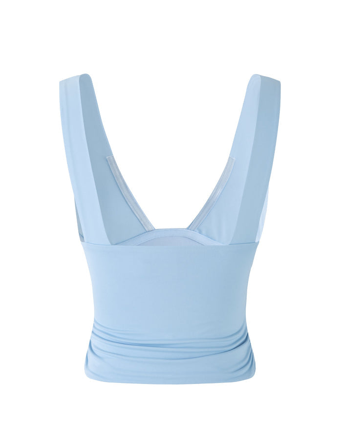 A BABY BLUE LUNARIA TOP from TIGERMIST, featuring wide shoulder straps, is showcased. The tank top boasts a sleek, fitted design with a deep V-shaped back. Crafted from smooth, lightweight fabric, it promises a comfortable fit perfect for casual wear. A plain white background accentuates the garment.