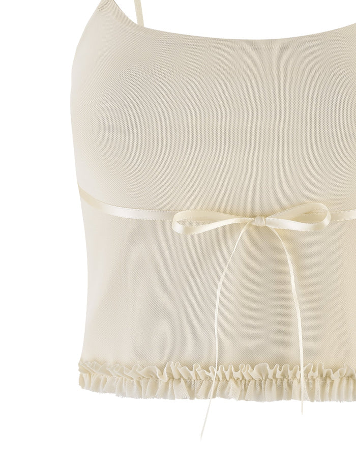 A close-up of the TIGERMIST MAISIE TOP in pale yellow featuring adjustable shoulder straps, a satin bow at the front, mesh fabric, and a ruffled hem.