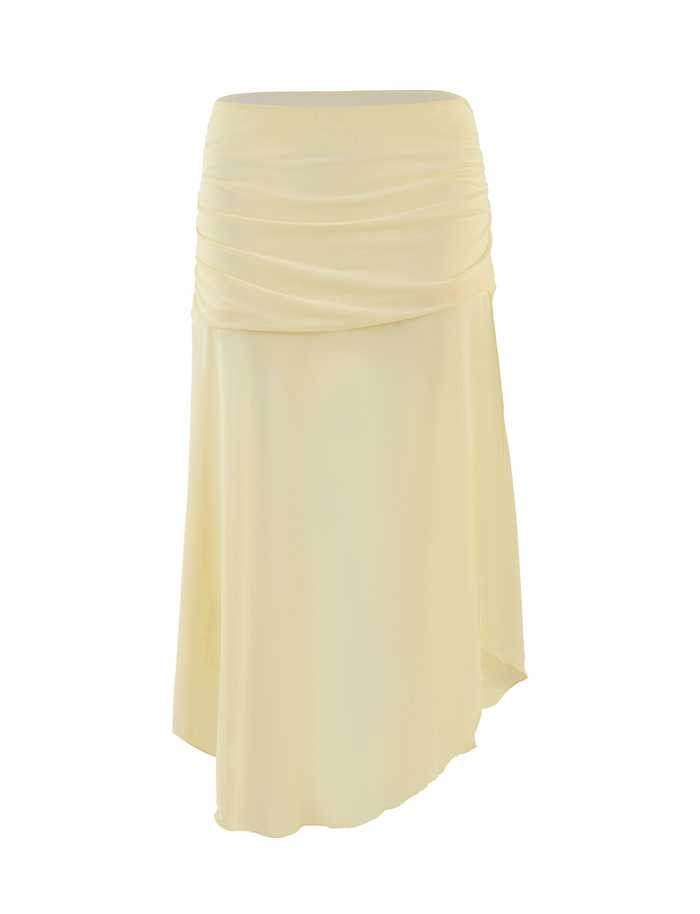 The MARIANA SKIRT by TIGERMIST in pale yellow is a knee-length midi with a ruched waistband, asymmetrical hem, and high-stretch fabric, shown against a plain white background.
