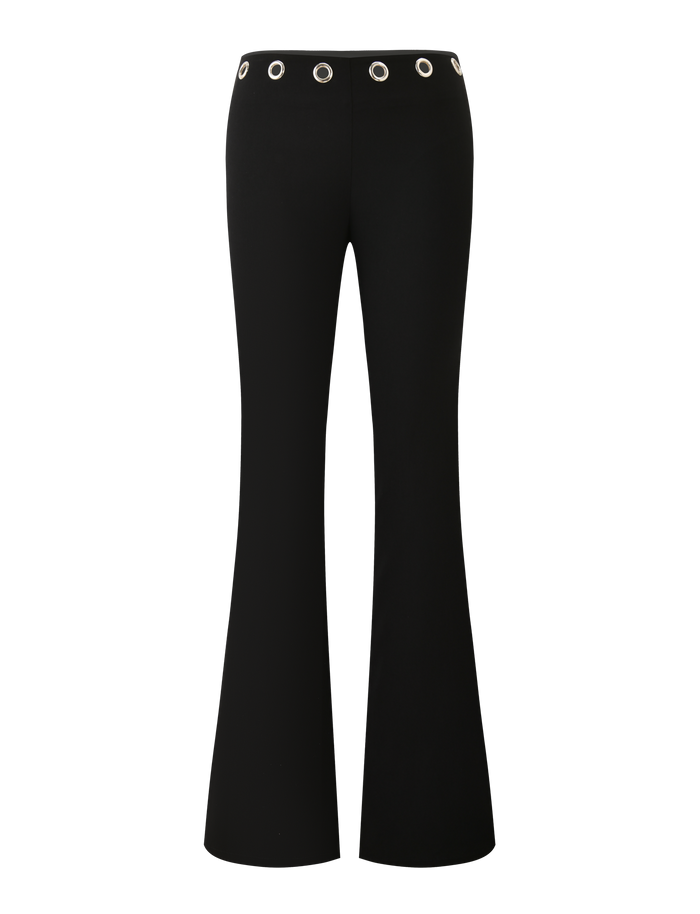 The MARREN PANT - BLACK by TIGERMIST features a low-rise waist, wide flared legs, and silver grommets around the waistband. Shown against a plain white background.