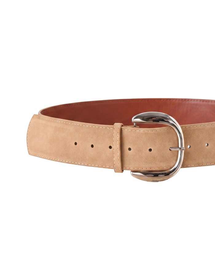 The MARTINA BELT - TAN by TIGERMIST is a tan faux suede belt featuring a large silver buckle and multiple adjustment holes, shown against a white background.
