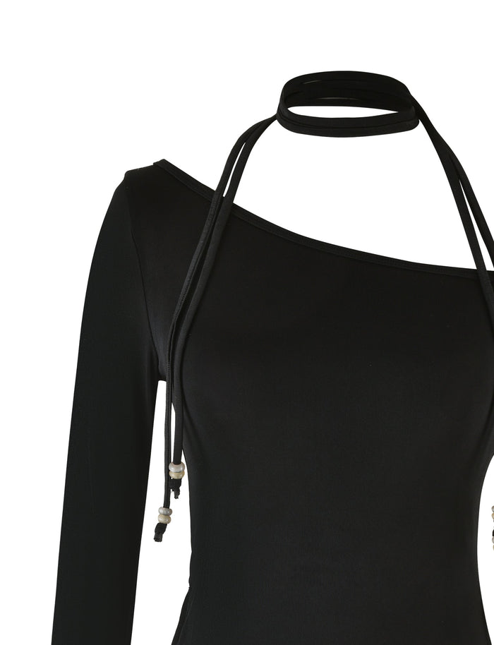 The MIETTA TOP - BLACK by TIGERMIST is a black, long-sleeve top with an asymmetrical neckline and a thin halter strap. Made from high stretch fabric, it fits smoothly and drapes elegantly from the left shoulder to the right underarm. The multi-tie neck strap loops around stylishly, adding a chic element.