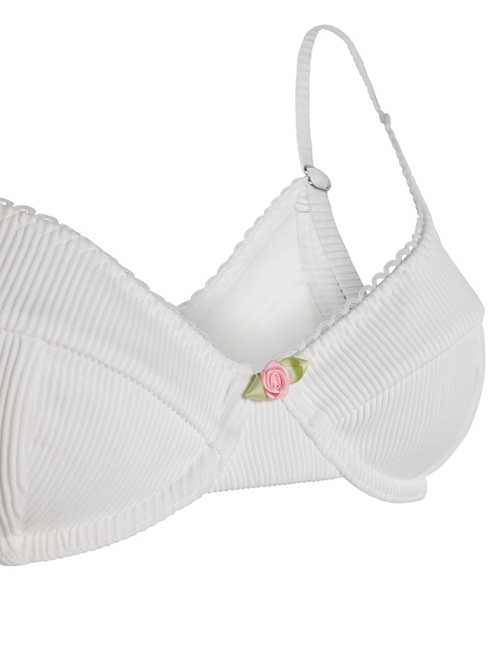 The MILANA BIKINI TOP - WHITE by TIGERMIST is a white ribbed balconette bikini top featuring scalloped edges, adjustable straps, underwire support, and a pink rose embellishment at the center front.