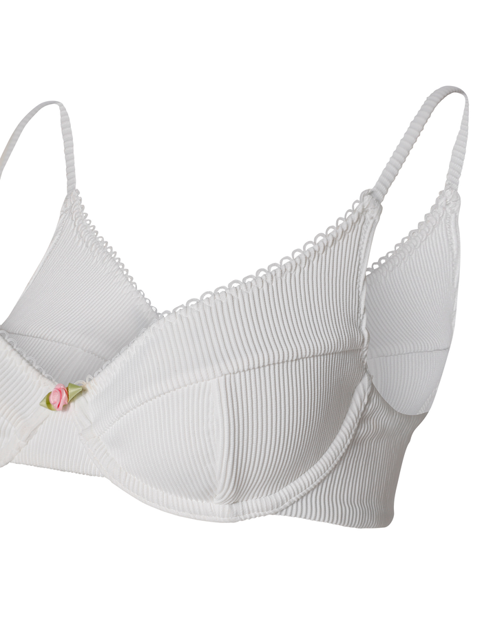 The MILANA BIKINI TOP - WHITE by TIGERMIST is a white ribbed balconette bikini top with underwire support, scalloped edges, adjustable straps, and a pink rose detail at the center.