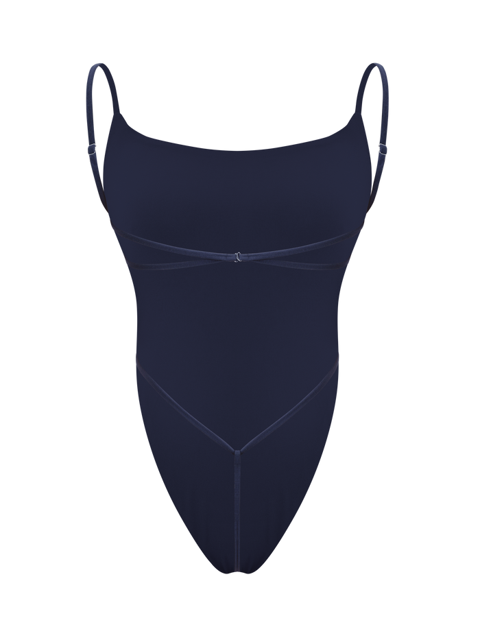 The TIGERMIST MINERVA BODYSUIT - NAVY is a sleek, backless one-piece with thin adjustable straps and subtle seam detailing, shown against a white background.