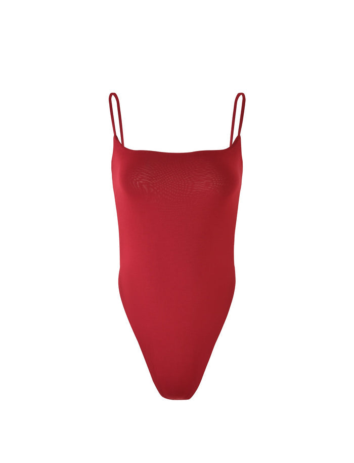 The MINERVA BODYSUIT - RED from TIGERMIST features thin spaghetti straps and a high-cut leg design. The smooth, stretchable fabric ensures a snug fit, and the garment is displayed against a plain white background.