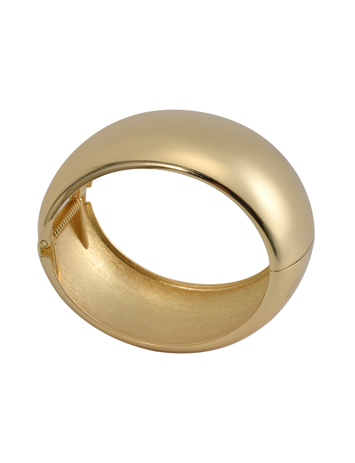 The MIRAH CHUNKY BANGLE - GOLD by TIGERMIST is a shiny, thick gold cuff with a smooth, rounded surface and hinged clasp, shown open on a plain white background for a bold, statement look.