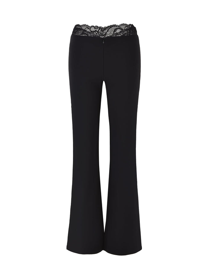The NYOMI PANT - BLACK by TIGERMIST features a flared leg and intricate lace detailing at the waistline, presented against a plain white backdrop.