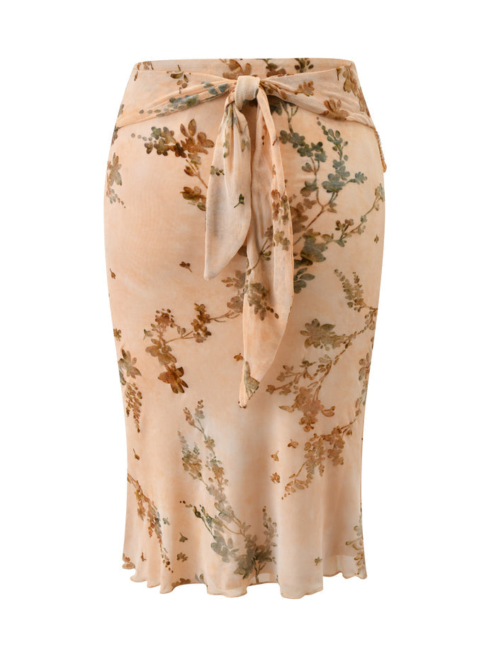 The OONA BURN OUT FRINGE SKIRT in tan by TIGERMIST is a slim-fit midi skirt with soft, flowing fabric, a removable waistband, and a tied bow at the back waist for effortless style.